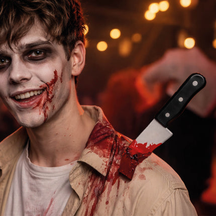 Cuchillo de mentira de Halloween clavado en el hombro