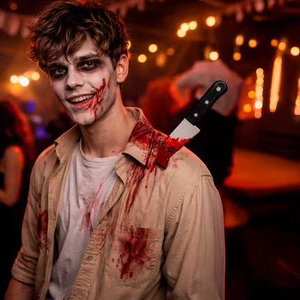 Cuchillo de mentira de Halloween clavado en el hombro